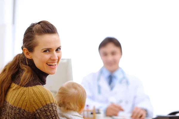 Szczęśliwa matka z dzieckiem w dziecięcej lekarz gabinet — Zdjęcie stockowe