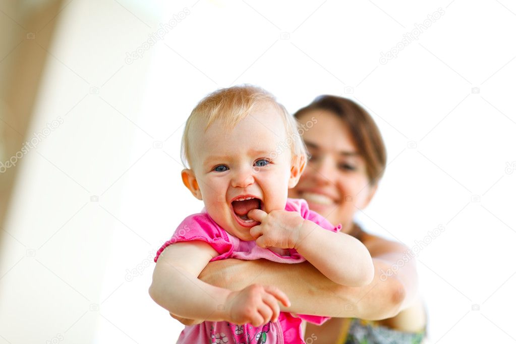 Laughing baby playing with mother