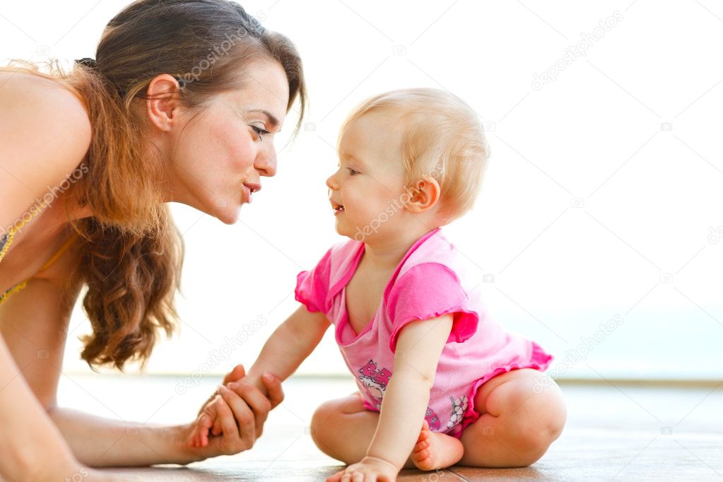 Young mother playing with baby on floor