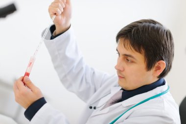 Medical doctor working with blood sample in laboratory clipart