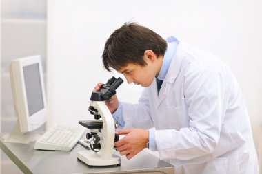 Medical doctor working with microscope in laboratory clipart