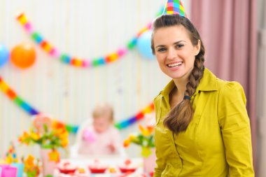 Portrait of mother and celebrating baby in background clipart