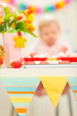 portre üzerinde doğum günü pastası ve arka planda lekeli bebek yemek