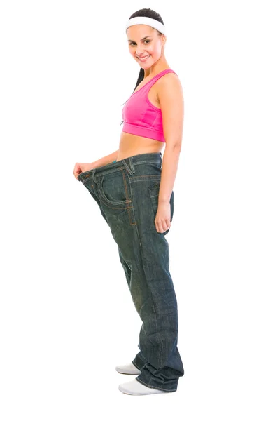 Chica delgada tirando de pantalones vaqueros de gran tamaño. Concepto de pérdida de peso —  Fotos de Stock