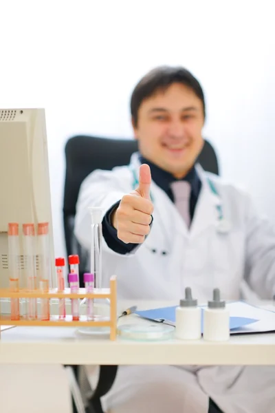 Lekarz uśmiechający się przedstawienie kciuki w górze. skupić się na strony — Zdjęcie stockowe