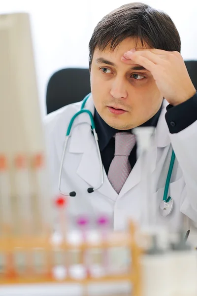 Concerned medical doctor working on computer at office — Stock Photo, Image
