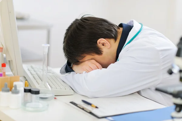 Müder Arzt schläft auf Tastatur — Stockfoto