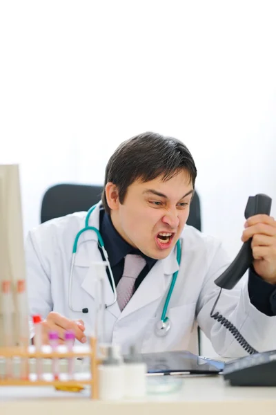 Angry medical doctor shouting in phone handset — Stock Photo, Image