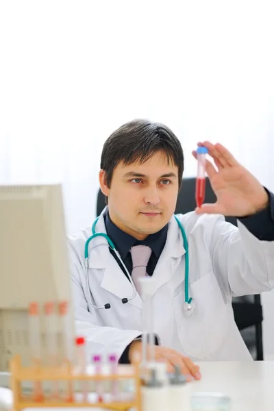 Lékař kontrola trubice s krevním vzorkem — Stock fotografie