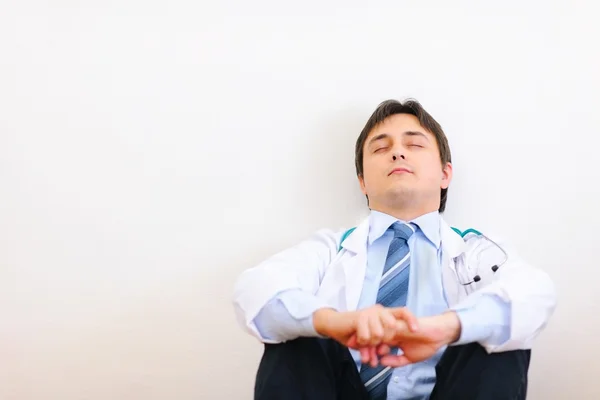 Müder Arzt sitzt auf dem Boden und entspannt — Stockfoto