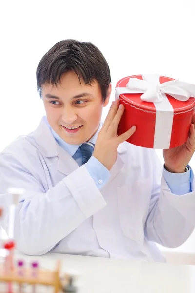 Happy medical doctor shaking present box trying to guess whats i — Stock Photo, Image