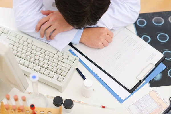 Closeup on tired medical doctor sleeping on table — Stock Photo, Image