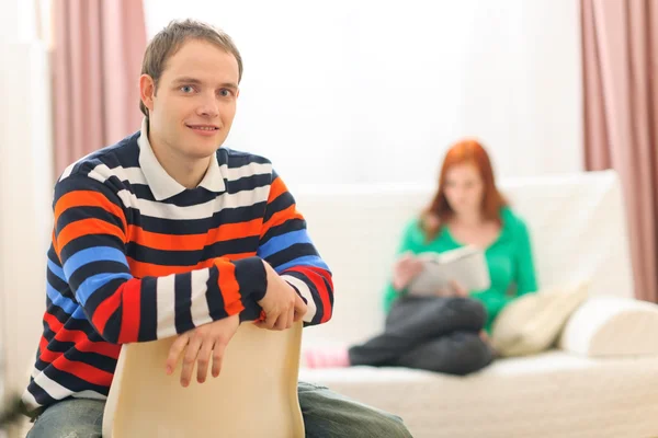 Portrait of young man and girlfriend reading in background — Stock Photo, Image