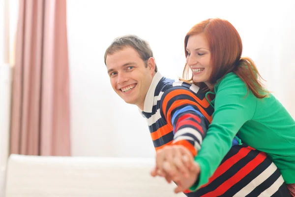 Smiling red hair young woman piggybacking boyfriend — Stock Photo, Image
