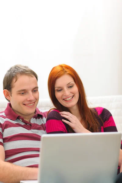 Feliz pareja joven que se divierte con el ordenador portátil — Foto de Stock