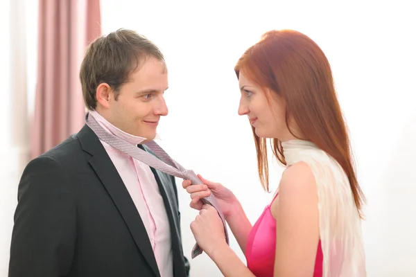 Zrzavé vlasy mladá žena pomáhá uvázat kravatový — Stock fotografie