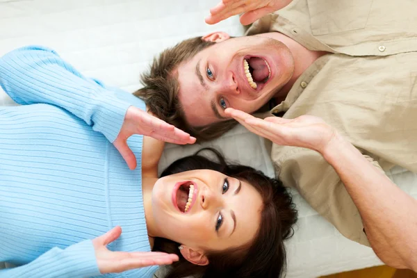 Jovem casal gritando através de mãos em forma de megafone — Fotografia de Stock