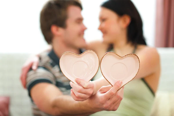 Närbild på valentines hjärtan i händerna på romantiska par — Stockfoto