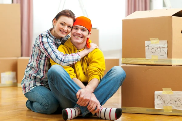 Portrait of moving to new house young couple among boxes — Stock Photo, Image