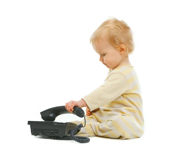 Симпатичный ребенок играет с телефоном на белом фоне — стоковое фото
