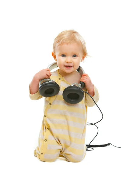 Happy baby med hörlurar letar du på copyspace isolerad på whit — Stockfoto