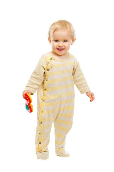 Sonriente niño de pie con sonajero sobre fondo blanco — Foto de Stock