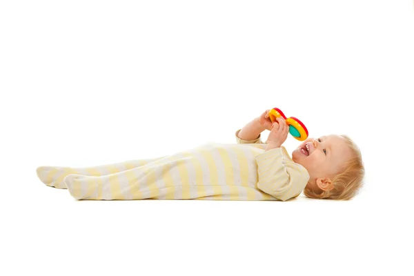 Criança bonito deitado no chão com chocalho isolado em branco — Fotografia de Stock