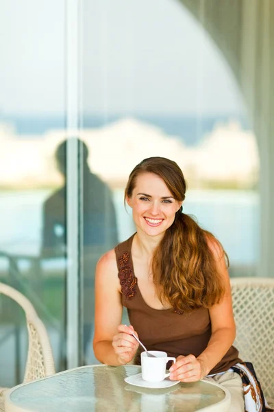 Glad ung kvinna med kopp kaffe på terrassen — Stockfoto