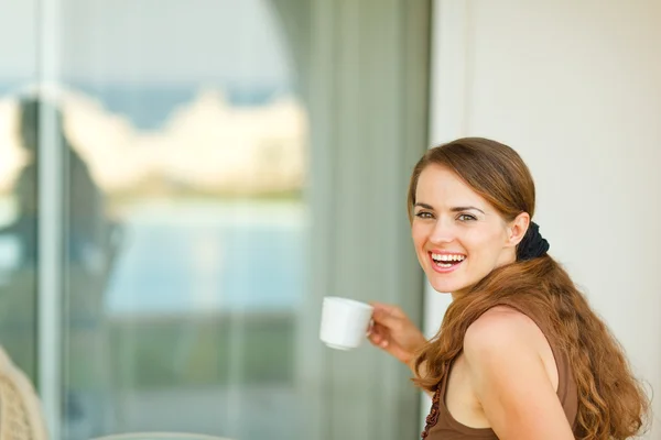 Ευτυχής νεαρή γυναίκα έχοντας το φλιτζάνι του καφέ — Φωτογραφία Αρχείου