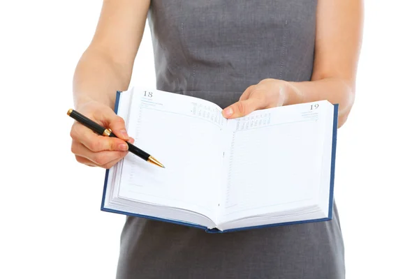 Fechar na caneta apontando em bloco de notas aberto em mãos de fêmea — Fotografia de Stock