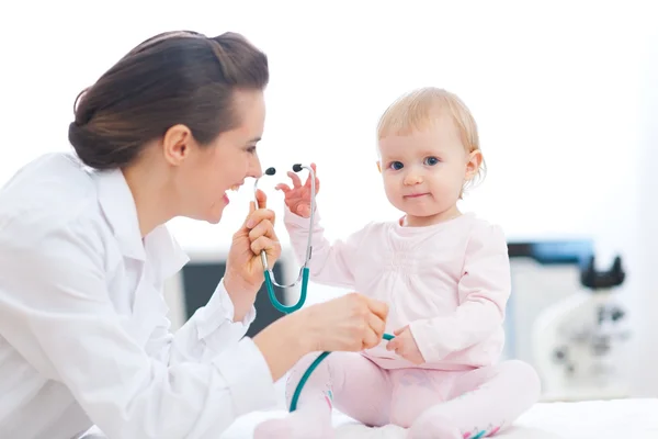 Médico pediatra brincando com bebê no exame — Fotografia de Stock