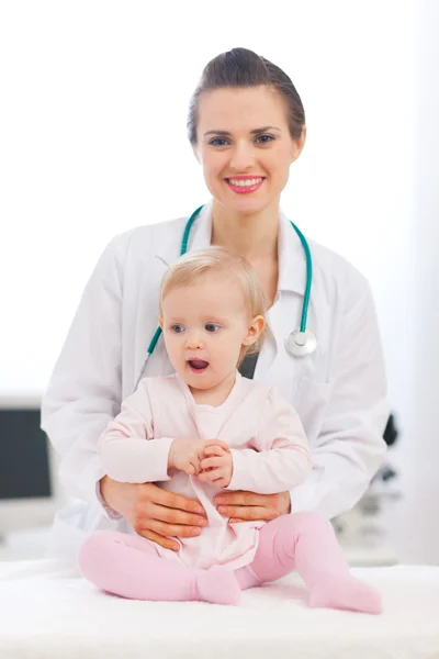 Portret van pediatrische arts met een baby op zoek op kant — Stockfoto