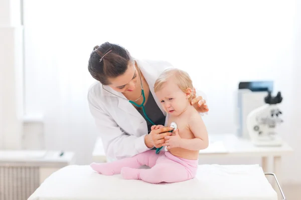 小児の医師は、泣いている赤ちゃんを検査します。 — ストック写真