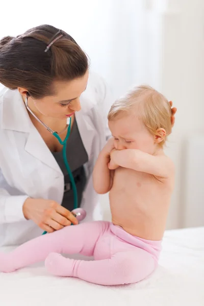 Врач-педиатр успокаивает плачущего ребенка — стоковое фото