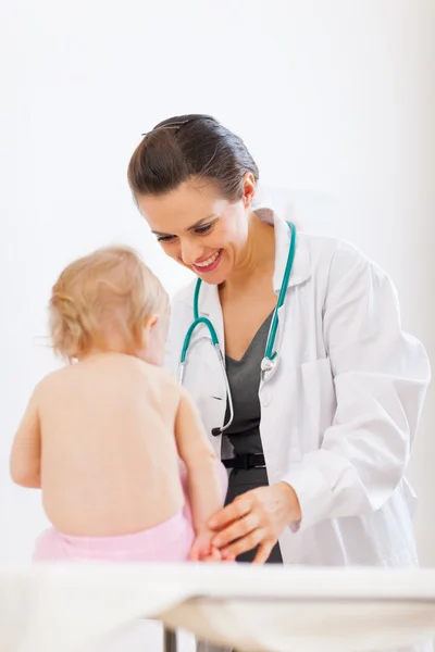 Médico pediatra jugando con bebé en la encuesta —  Fotos de Stock