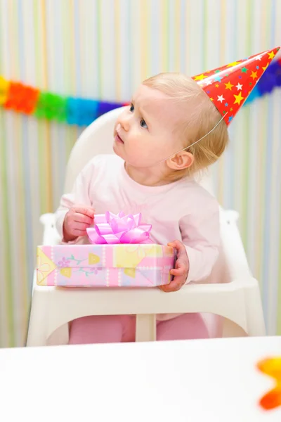 Baby with present looking in corner — Stock Photo, Image