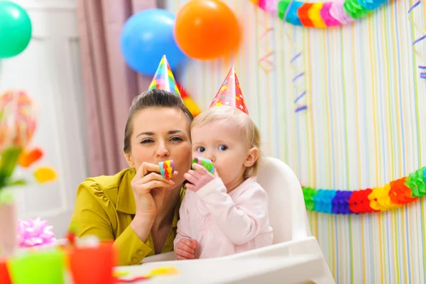 Baby und Mutter blasen in Partyhorn — Stockfoto