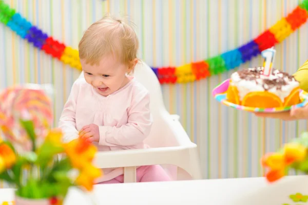 Baby happy and embarrassed receiving birthday cake — Stock Photo, Image