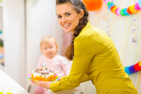 Glad mamma bär födelsedagstårta för barn — Stockfoto