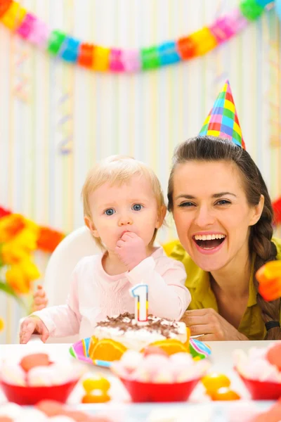 Портрет матери с ребенком, наслаждающейся тортом на первый день рождения — стоковое фото