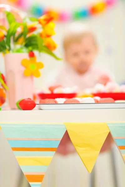 Primer plano en pastel de cumpleaños y comer bebé untado en el fondo — Foto de Stock