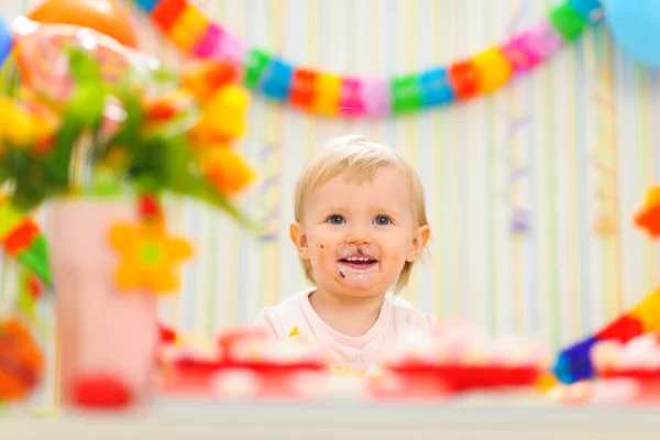 Retrato de comer untado bebé celebrando su primer cumpleaños —  Fotos de Stock