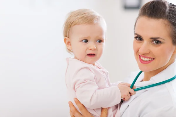 Portrait of pediatrician doctor with distrustful baby Stock Photo