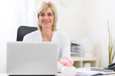 Portrait of happy senior business woman at office clipart