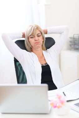Tired senior business woman looking on computer clipart