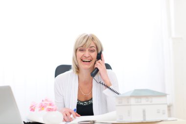 Happy senior architect woman having good news phone call clipart