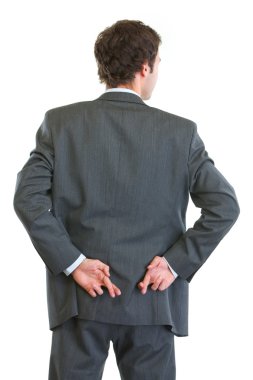 Business man standing back to camera with crossed fingers clipart