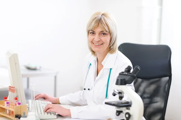 Portrait of smiling mature doctor woman at laboratory — Stock Photo, Image