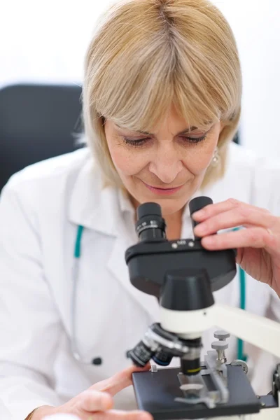 Senior vrouwelijke onderzoeker op zoek in Microscoop — Stockfoto