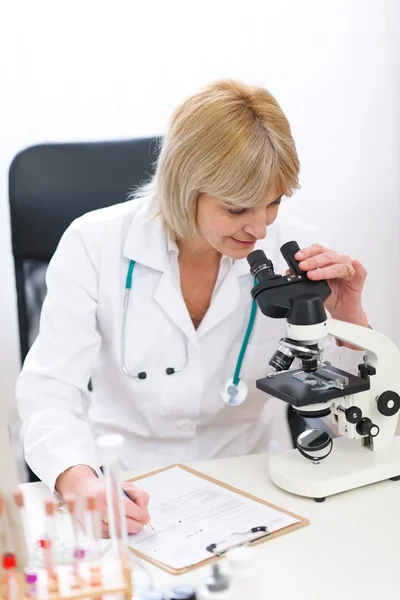 Mikroskopla çalışan kıdemli doktor kadın — Stok fotoğraf